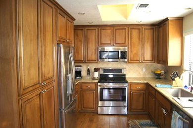 サクラメントにあるトラディショナルスタイルのおしゃれなキッチン (レイズドパネル扉のキャビネット、中間色木目調キャビネット) の写真