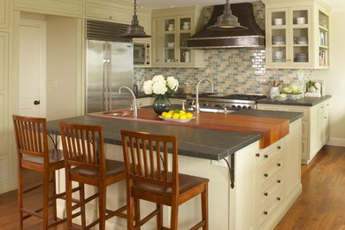 Inspiration for a large eclectic u-shaped medium tone wood floor eat-in kitchen remodel in San Francisco with shaker cabinets, green cabinets, soapstone countertops, multicolored backsplash, porcelain backsplash, stainless steel appliances and an island