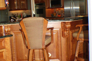 クリーブランドにあるおしゃれなキッチン (中間色木目調キャビネット、シルバーの調理設備、無垢フローリング) の写真