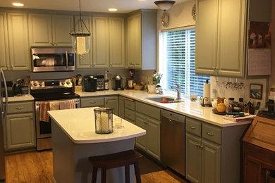 シアトルにある中くらいなトラディショナルスタイルのおしゃれなキッチン (ダブルシンク、レイズドパネル扉のキャビネット、グレーのキャビネット、珪岩カウンター、シルバーの調理設備、無垢フローリング、茶色い床) の写真