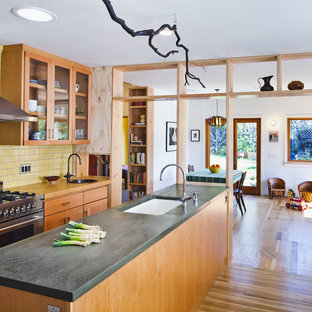Design ideas for a contemporary kitchen in San Francisco with glass-front cabinets, concrete benchtops, stainless steel appliances, a single-bowl sink, medium wood cabinets, yellow splashback and subway tile splashback.