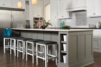 Mid-sized transitional l-shaped dark wood floor eat-in kitchen photo in Boston with shaker cabinets, white cabinets, solid surface countertops, white backsplash, subway tile backsplash, stainless steel appliances and an island