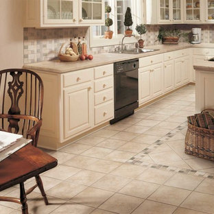 Mid-sized traditional eat-in kitchen ideas - Mid-sized elegant l-shaped ceramic tile eat-in kitchen photo in Manchester with a drop-in sink, raised-panel cabinets, light wood cabinets, tile countertops, beige backsplash, ceramic backsplash, white appliances and an island