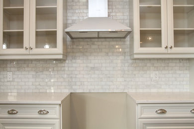 Imagen de cocina actual con armarios con paneles empotrados, puertas de armario blancas, encimera de acrílico, salpicadero blanco y salpicadero de azulejos de piedra