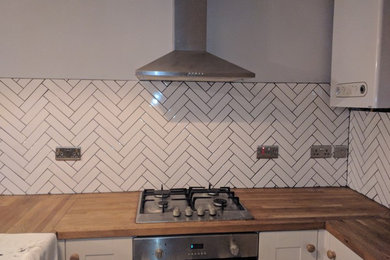 エディンバラにあるお手頃価格のラスティックスタイルのおしゃれなペニンシュラキッチン (木材カウンター、白いキッチンパネル、セラミックタイルのキッチンパネル) の写真
