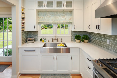 Inspiration for a small transitional u-shaped medium tone wood floor eat-in kitchen remodel with a farmhouse sink, shaker cabinets, white cabinets, quartz countertops, blue backsplash, ceramic backsplash, stainless steel appliances, no island and white countertops