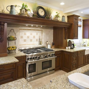 Rustic kitchen designs - Example of a mountain style kitchen design in Chicago with an undermount sink, raised-panel cabinets, dark wood cabinets, beige backsplash and stainless steel appliances