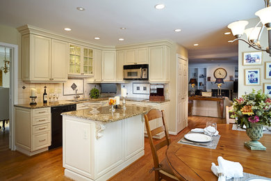 Medium sized traditional l-shaped kitchen in DC Metro with a submerged sink, recessed-panel cabinets, beige cabinets, beige splashback, porcelain splashback, stainless steel appliances, light hardwood flooring and an island.