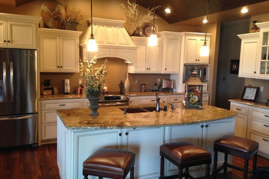 This is an example of a large classic l-shaped kitchen/diner in Other with a submerged sink, recessed-panel cabinets, yellow cabinets, laminate countertops, stainless steel appliances, medium hardwood flooring, multiple islands and brown floors.