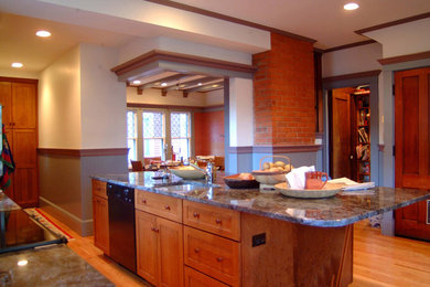 Example of a large trendy single-wall light wood floor eat-in kitchen design in Bridgeport with an undermount sink, shaker cabinets, medium tone wood cabinets, granite countertops, black appliances and an island