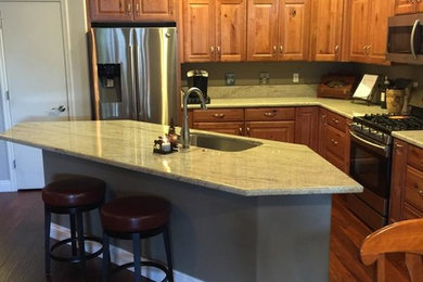 Kitchen photo in Las Vegas with an undermount sink, light wood cabinets, granite countertops and stainless steel appliances
