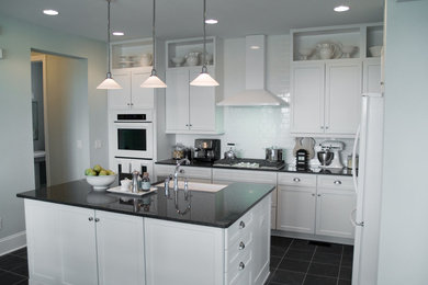 Inspiration for a mid-sized contemporary l-shaped enclosed kitchen remodel in Boston with recessed-panel cabinets, white cabinets, granite countertops, white backsplash, subway tile backsplash, stainless steel appliances and an island