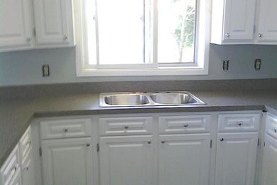 Example of a mid-sized transitional u-shaped eat-in kitchen design in Grand Rapids with a double-bowl sink, raised-panel cabinets, white cabinets, stainless steel appliances and no island