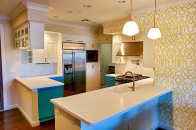 1950s u-shaped medium tone wood floor and brown floor open concept kitchen photo in Phoenix with an undermount sink, shaker cabinets, white cabinets, quartz countertops, white backsplash, mosaic tile backsplash, stainless steel appliances, a peninsula and white countertops