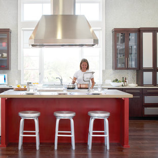 Idee per una cucina chic con ante di vetro, ante in legno bruno, top in granito, paraspruzzi in lastra di pietra, elettrodomestici in acciaio inossidabile, parquet scuro e isola