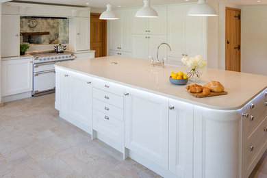 Contemporary open plan kitchen in Other with an integrated sink, shaker cabinets, white cabinets, quartz worktops, metallic splashback, mirror splashback and an island.