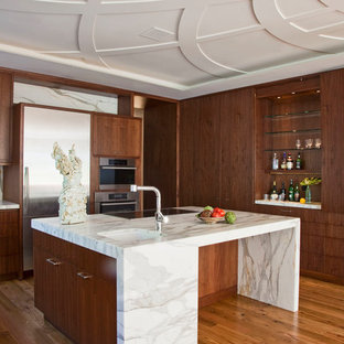 Mid-sized trendy medium tone wood floor and beige floor kitchen photo in Santa Barbara with flat-panel cabinets, marble countertops, white backsplash, marble backsplash, stainless steel appliances, an island, an undermount sink and dark wood cabinets