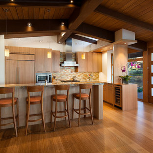 Mid-sized midcentury l-shaped open plan kitchen in Santa Barbara with flat-panel cabinets, light wood cabinets, marble benchtops, multi-coloured splashback, matchstick tile splashback, panelled appliances, bamboo floors, with island and beige floor.