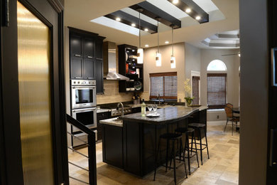Eat-in kitchen - mid-sized contemporary l-shaped beige floor and limestone floor eat-in kitchen idea in Other with an undermount sink, shaker cabinets, granite countertops, beige backsplash, stone tile backsplash, stainless steel appliances, an island and dark wood cabinets
