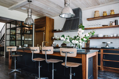 Eat-in kitchen - rustic dark wood floor eat-in kitchen idea in Atlanta with ceramic backsplash, an island, recessed-panel cabinets, black cabinets, black backsplash, paneled appliances and gray countertops