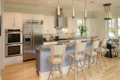 Eat-in kitchen - large transitional single-wall light wood floor and beige floor eat-in kitchen idea in Charleston with an undermount sink, flat-panel cabinets, white cabinets, granite countertops, white backsplash, mosaic tile backsplash, stainless steel appliances and an island