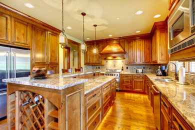 Large elegant u-shaped medium tone wood floor eat-in kitchen photo in New York with a double-bowl sink, recessed-panel cabinets, medium tone wood cabinets, granite countertops and an island