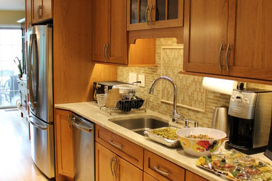 Example of a mid-sized arts and crafts light wood floor and brown floor kitchen design in New York with an undermount sink, shaker cabinets, medium tone wood cabinets, multicolored backsplash, glass tile backsplash and stainless steel appliances