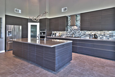 Eat-in kitchen - large contemporary u-shaped ceramic tile and brown floor eat-in kitchen idea in Los Angeles with flat-panel cabinets, gray cabinets, granite countertops, stainless steel appliances, an island, an undermount sink, multicolored backsplash, matchstick tile backsplash and gray countertops