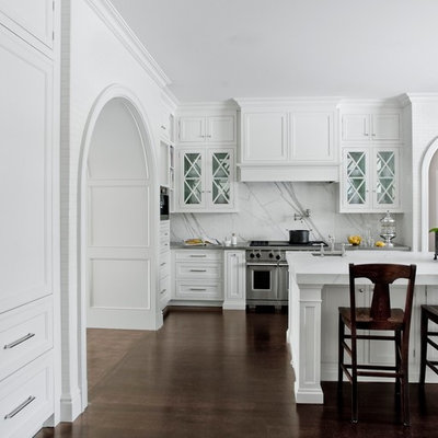 Example of a classic kitchen design in Detroit with glass-front cabinets, white cabinets, white backsplash, stainless steel appliances and marble backsplash