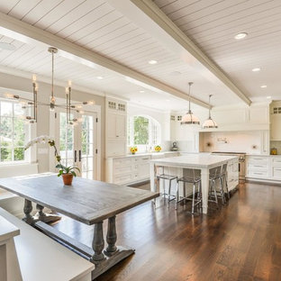 Foto di una cucina chic con ante con riquadro incassato, ante bianche, paraspruzzi bianco, elettrodomestici in acciaio inossidabile, parquet scuro e isola