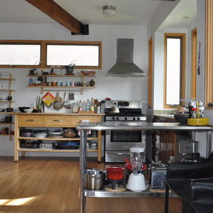Mid-sized midcentury u-shaped open plan kitchen in San Francisco with a drop-in sink, open cabinets, stainless steel cabinets, wood benchtops, stainless steel appliances, bamboo floors and a peninsula.