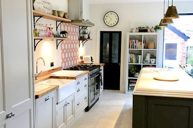 Photo of a medium sized bohemian single-wall kitchen/diner in Other with a belfast sink, shaker cabinets, grey cabinets, marble worktops, pink splashback, cement tile splashback, stainless steel appliances, ceramic flooring, an island and beige floors.