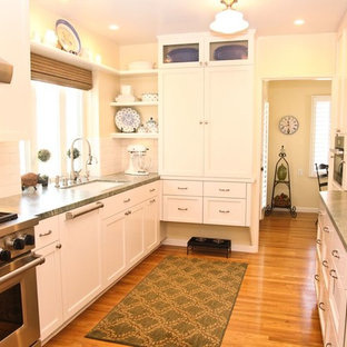 Inspiration for a mid-sized shabby-chic style galley separate kitchen in San Diego with an undermount sink, shaker cabinets, white cabinets, quartz benchtops, white splashback, subway tile splashback, panelled appliances, medium hardwood floors, no island and brown floor.