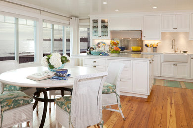 Eat-in kitchen - large coastal l-shaped medium tone wood floor eat-in kitchen idea in San Francisco with an island, beaded inset cabinets, white cabinets, marble countertops, white backsplash, stainless steel appliances and a farmhouse sink