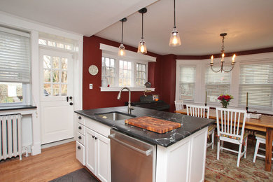 Example of a classic eat-in kitchen design in Philadelphia with recessed-panel cabinets, white cabinets, soapstone countertops, white backsplash and stainless steel appliances