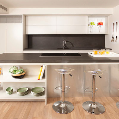 Kitchen - modern galley kitchen idea in Other with flat-panel cabinets, white cabinets, gray backsplash and paneled appliances