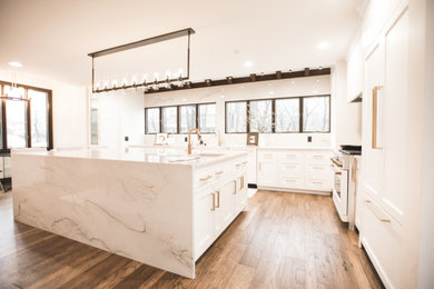 Example of a minimalist kitchen design in Other with quartzite countertops, white backsplash, stone slab backsplash, an island and white countertops