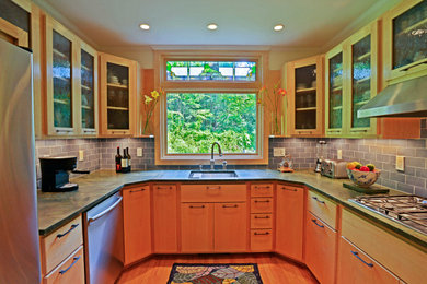 Example of an eclectic u-shaped medium tone wood floor kitchen design in Boston with an undermount sink, glass-front cabinets, light wood cabinets, granite countertops, blue backsplash, ceramic backsplash, stainless steel appliances, no island and green countertops
