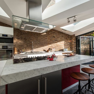 This is an example of a mid-sized contemporary single-wall eat-in kitchen in London with an integrated sink, flat-panel cabinets, white cabinets, marble benchtops, stainless steel appliances, ceramic floors and with island.