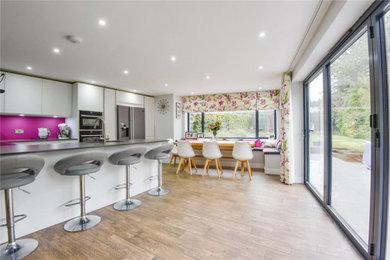 This is an example of a contemporary kitchen/dining room in Essex with grey walls, ceramic flooring and brown floors.