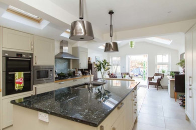 Photo of a large classic u-shaped open plan kitchen in London with granite worktops and a breakfast bar.