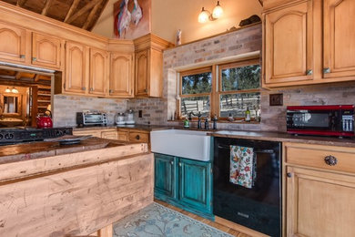 Inspiration for a rustic l-shaped medium tone wood floor eat-in kitchen remodel in Denver with a farmhouse sink, raised-panel cabinets, distressed cabinets, granite countertops and an island