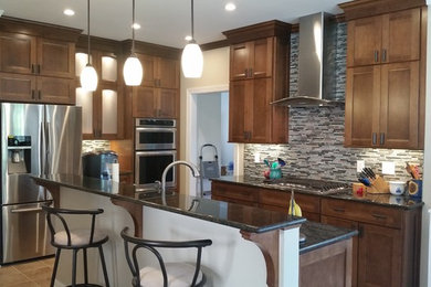 Large arts and crafts galley porcelain tile open concept kitchen photo in Richmond with an undermount sink, shaker cabinets, medium tone wood cabinets, granite countertops, multicolored backsplash, subway tile backsplash, stainless steel appliances and an island