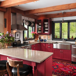 Photo of a mid-sized country u-shaped kitchen in Chicago with stainless steel appliances, a farmhouse sink, red cabinets, brown floor, louvered cabinets, granite benchtops and dark hardwood floors.