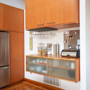 Foto de cocina contemporánea con armarios con paneles lisos, puertas de armario de madera oscura y electrodomésticos de acero inoxidable