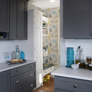 Mid-sized transitional eat-in kitchen designs - Mid-sized transitional u-shaped dark wood floor and brown floor eat-in kitchen photo in Milwaukee with a farmhouse sink, shaker cabinets, gray cabinets, white backsplash, subway tile backsplash, stainless steel appliances, a peninsula, quartzite countertops and gray countertops