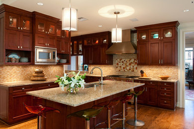 Example of a mid-sized country l-shaped light wood floor eat-in kitchen design in Dallas with a drop-in sink, shaker cabinets, medium tone wood cabinets, limestone countertops, multicolored backsplash, matchstick tile backsplash, stainless steel appliances and an island