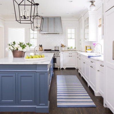 Kitchen - traditional dark wood floor kitchen idea in New York with an undermount sink, shaker cabinets, white cabinets, white backsplash, subway tile backsplash, stainless steel appliances and an island