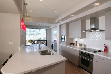 Example of a transitional kitchen design in Salt Lake City with white backsplash, stainless steel appliances and white countertops
