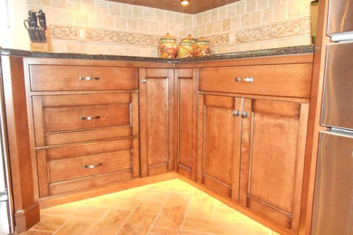 Imagen de cocina de tamaño medio con puertas de armario de madera oscura, encimera de cuarzo compacto y electrodomésticos de acero inoxidable